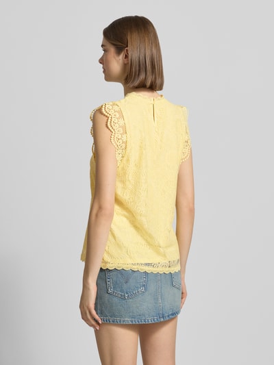 Frauenmodel trägt Shaped Fit Blusentop mit Spitzenbesatz Modell 'OLLINE' von Pieces, Optik: Unifarben, Florales-Muster, Spitzenbesatz, Label-Stitching-Applikation, Rundhals, 1-Knopf-Verschluss, Schlüsselloch, Materialverarbeitung: Spitze, gelb, strukturierte Oberfläche, Ganzkörperansicht Rückansicht.