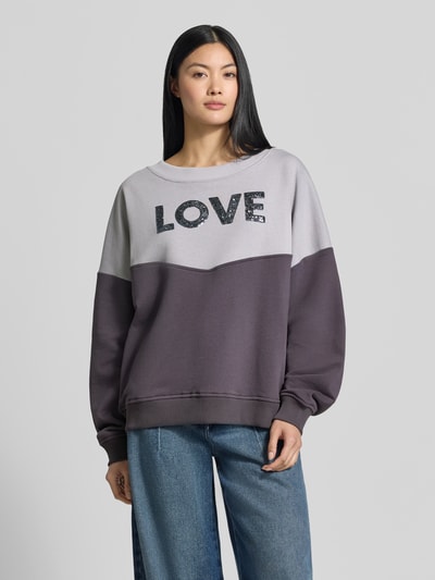 Frauenmodel trägt Oversized Sweatshirt aus reiner Baumwolle von miss goodlife, zweifarbig, Paillettenbesatz, Ganzkörperansicht von vorne.