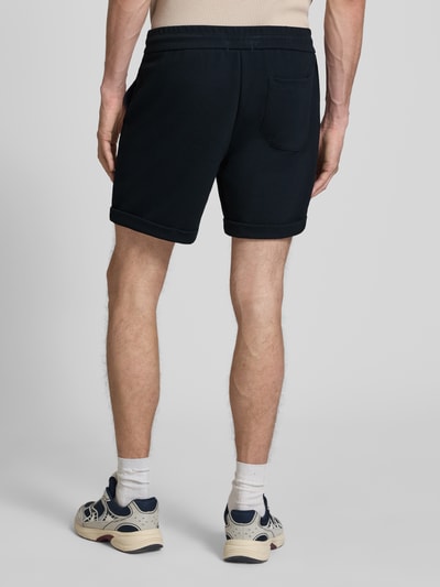 Männermodel trägt Regular Fit Shorts mit Viskose-Anteil Modell 'NEWKODYL' von Only & Sons, Melange-Optik, Nadelstreifen-Muster, Gesäßtasche, elastischer Bundabschluss mit Tunnelzug, fixierter Beinabschluss, Eingrifftaschen, Ganzkörperansicht Rückansicht.