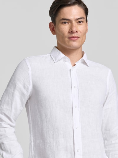 Männermodel trägt weißes Casual Fit Leinenhemd mit Kentkragen Modell 'Mike' von JOOP! Collection, Nahaufnahme Oberkörper. Reines Leinen, Knopfleiste, Sportmanschetten, abgerundeter Saum, Rückenlänge bei Größe M: 73 cm, Schulterbreite: 40 cm, Ärmellänge: 66 cm.