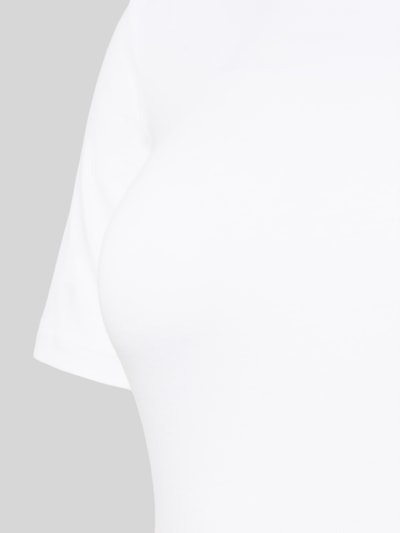 Kobiece model prezentuje Slim Fit Body z logo-patch od Skiny, mieszanka bawełny, okrągły dekolt, krótki rękaw, zapięcie na zatrzask. Zbliżenie na górną część ciała.