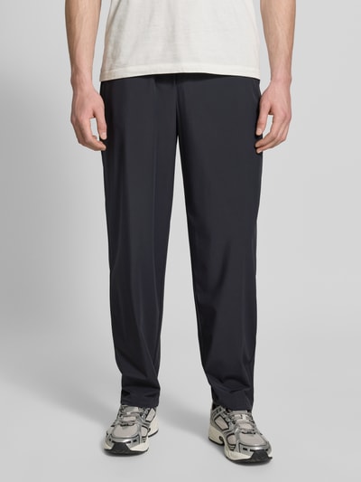Męski model nosi Hose mit elastischem Bund und Gesäßtaschen od ARMANI EXCHANGE, czarny, materiał z domieszką stretchu, krój relaxed fit, elastyczny pas, kieszenie z tyłu, szerokość w rozmiarze 32: 40 cm, długość nogawki wewnętrznej: 79 cm, zdjęcie w całej postaci z przodu.