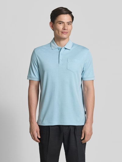 Męski model nosi Regular Fit Poloshirt mit Brusttasche und Label-Stitching od bugatti, jasnoniebieski, kołnierzyk polo, listwa guzikowa, wyhaftowane logo, brustasza, długość tyłu w rozmiarze M: 70 cm, Ganzkörperansicht von vorne.