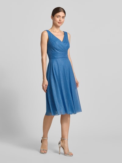 Frauenmodel trägt knielanges Cocktailkleid mit V-Ausschnitt von TROYDEN COLLECTION aus blauem Chiffon, Taillierter Schnitt, Breite Träger, Rückseitiger V-Ausschnitt, Rückenreißverschluss, Rückenlänge bei Größe 36: 85 cm, Brustweite bei Größe 36: 43 cm, Ganzkörperansicht von vorne.