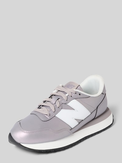 Produktfoto, Sneaker aus Leder-Mix von New Balance in hellem Grau mit weißen Details, sichtbare strukturierte Sohle, abgerundete Form, Label-Detail, Schnürverschluss, Damen Sneaker, Absatzhöhe 3 cm, Schafthöhe 8 cm, Schaftweite 7 cm, neutrale Hintergrundfarbe.