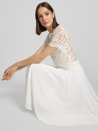 Modelka nosi Midirock aus Chiffon mit Reißverschluss von Luxuar, biały, zwiewny materiał, A-linia, Szerokość w rozmiarze 36: 38 cm, Długość całkowita: 77 cm, zdjęcie całej sylwetki z przodu.