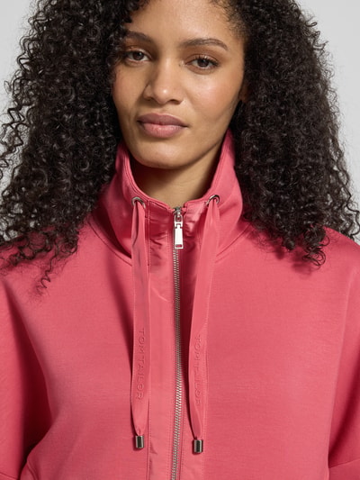 Vrouwenmodel draagt Boxy Fit Sweatjacke met Viskose-Anteil van Tom Tailor in effen kleur, scuba materiaal, labelprintdetails, nahaufnahme bovenlichaam.