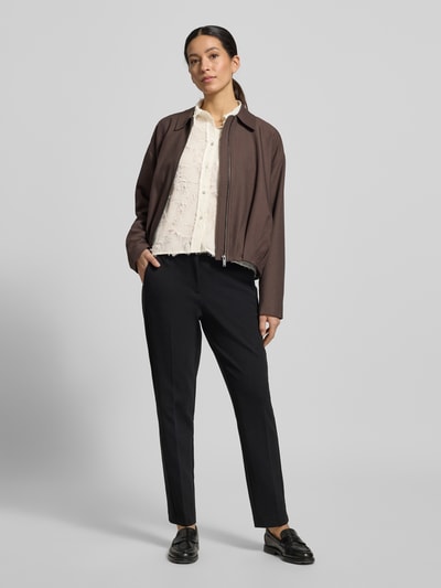 Frauenmodel trägt Boxy Fit Bluse im Allover-Look Modell 'Fenima' von OPUS in Creme mit Hemdblusenkragen und Knopfleiste, schwarze Hose, Ganzkörperansicht von vorne.