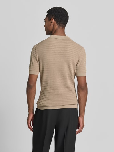 Männermodel trägt Slim Fit Strick-Poloshirt mit Strukturmuster Modell 'BRAIAN' von Drykorn in Beige, reine Baumwolle, Rückansicht.