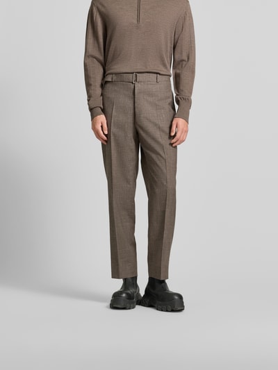 Männermodel trägt Anzughose aus Viskose-Mix von Officine Générale in Braun mit Bügelfalte und integriertem Gürtel, Ganzkörperansicht von vorne.