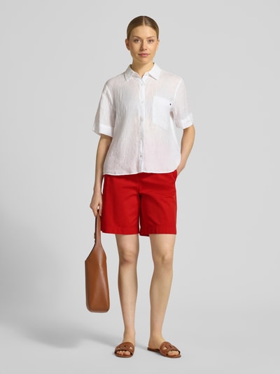 Kobiece model prezentuje Regular Fit Chino-Shorts aus Baumwoll-Lyocell-Mix od Tommy Hilfiger, efekt: jednolity kolor, krój regular fit, wyhaftowane logo, zapięcie na guzik i zamek błyskawiczny, wpuszczane kieszenie, kieszenie z tyłu, mieszanka bawełny i lyocellu; całkowity widok z przodu.