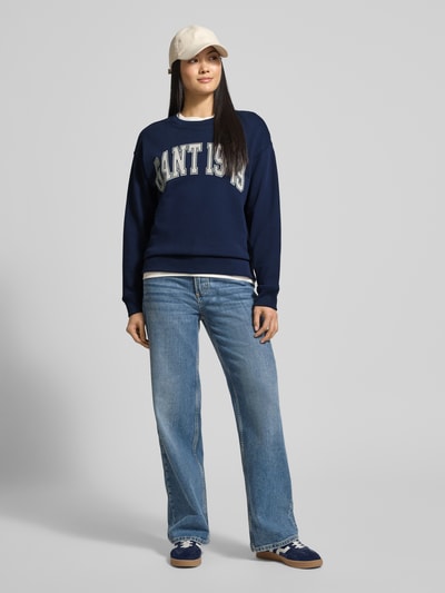 Frauenmodel trägt Sweatshirt mit Label-Print und Rundhalsausschnitt von Gant in Dunkelblau, Relaxed-Fit, Reine Baumwolle, Ganzkörperansicht von vorne.