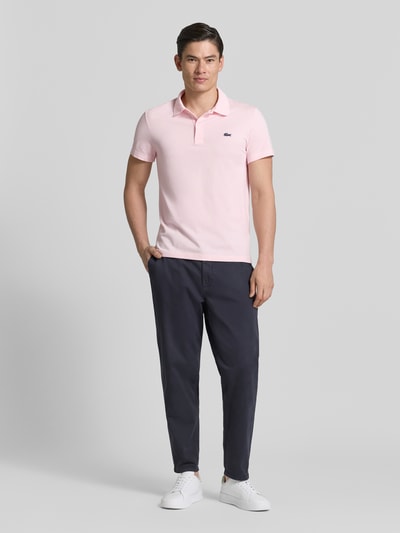 Männermodel trägt Regular Fit Poloshirt aus Baumwoll-Mix von Lacoste, Optik: Unifarben, Applikation: Logo-Patch, Polokragen, Kurzarm, Ganzkörperansicht von vorne.