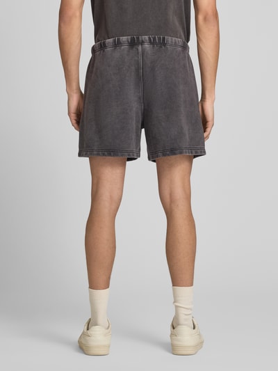 Männermodel trägt Sweatshorts mit Eingrifftaschen von CHAMPION in Anthrazit, Baumwoll-Mix, Regular Fit, Ganzkörperansicht Rückansicht.