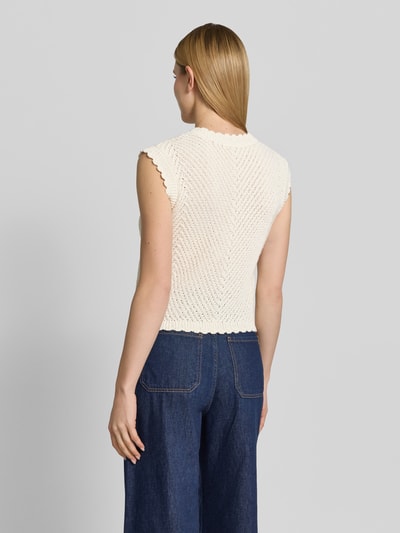 Frauenmodel trägt Strickweste mit V-Ausschnitt Modell 'Maisa' von mbyM, Grobstrick, Baumwoll-Mix, Gerader-Schnitt, Rückenlänge 52 cm, Ganzkörperansicht Rückansicht.
