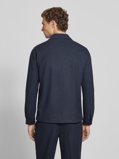 Męski model nosi Regular Fit Jacke mit Woll-Anteil von Lindbergh, elastyczna mieszanka materiałów, wykładany kołnierz, kieszenie na piersi, listwa guzikowa, długość tyłu w rozmiarze M: 72 cm, widok całej sylwetki z tyłu