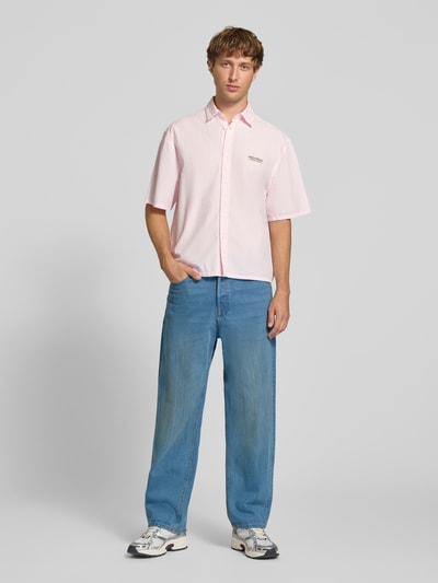 Männermodel trägt Straight Fit Jeans aus reiner Baumwolle Modell 'Alex' von JACK & JONES in klassischem Blau, Ganzkörperansicht von vorne. Passform, 5-Pocket-Design und Verschluss laut Beschreibung.