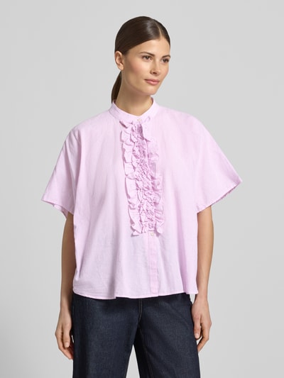 Modelka kobieca nosi Relaxed Fit bluzkę z falbanami model 'DAISY' z mieszanki lnu i bawełny od 0039 Italy, bladoróżowa, stójka, tekstura miękka, przód, zbliżenie na górną część ciała.