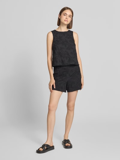 Modelka nosi Regular Fit Stoffshorts aus reiner Baumwolle Modell 'PCGINGER' od PIECES, czarny kolor, damskie szorty materiałowe, pełny widok z przodu.