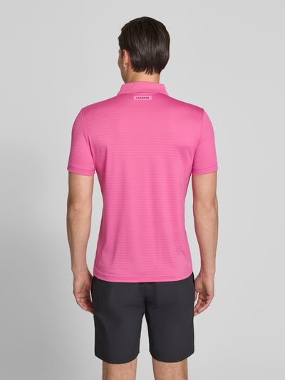 Męski model nosi Slim Fit Poloshirt aus schnelltrocknendem Material von Lacoste Sport, różowy, gładki, krój slim fit, logo, oddychający materiał, koszulka polo z krótkim zamkiem i krótkim rękawem, widok całej sylwetki od tyłu.
