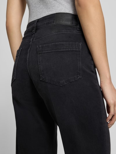 Vrouwenmodel draagt zwarte wide fit jeans uit katoenmix Model 'Carie' van someday., 5-pocketmodel, knoop- en ritssluiting, detailopname rugzijde.