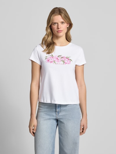 Frauenmodel trägt Regular Fit T-Shirt aus reiner Baumwolle Modell 'MAHINA' von Pepe Jeans, Optik: Unifarben, Motiv-Print, Label-Schriftzug, Rundhals, Kurzarm, weiße glatte Textur, Ganzkörperansicht von vorne.