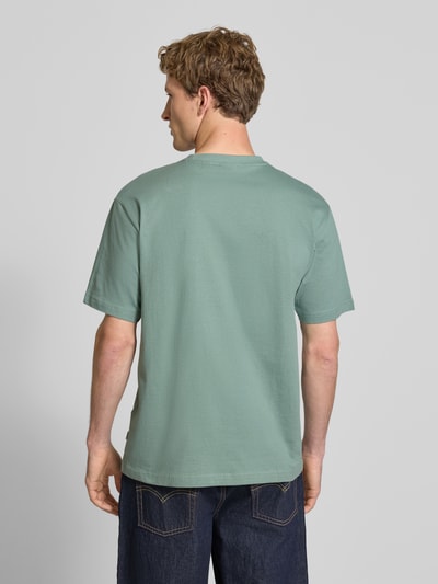 Männermodel trägt Relaxed Fit T-Shirt aus reiner Baumwolle Modell 'FRED LIFE' von Only & Sons, Optik: Unifarben, Ganzkörperansicht Rückansicht.