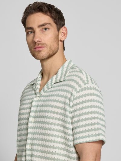 Männermodel trägt Relaxed Fit Poloshirt aus Baumwoll-Mix Modell 'DYLAN' von SELECTED HOMME, Optik:Allover-Muster, Nahaufnahme Oberkörper.