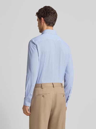 Męskki model nosi Slim Fit Businesshemd mit Kentkragen Modell 'KENNO' von HUGO, efekt: wzór na całej powierzchni, wzór, długi rękaw, kołnierzyk typu kent, mankiety, pas na plecach, listwa guzikowa jednorzędowa, zaokrąglone wykończenie, wyhaftowane logo, Ganzkörperansicht Rückansicht.