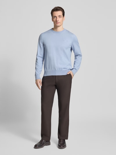 Męski model nosi Regular Fit Strickpullover aus reiner Baumwolle Modell 'UPCAS' von BOSS, efekt: jednolity kolor, wyhaftowane logo, dekolt okrągły, długi rękaw, zakończenia prążkowane, dzianina, bawełna, ganzkörperansicht von vorne.