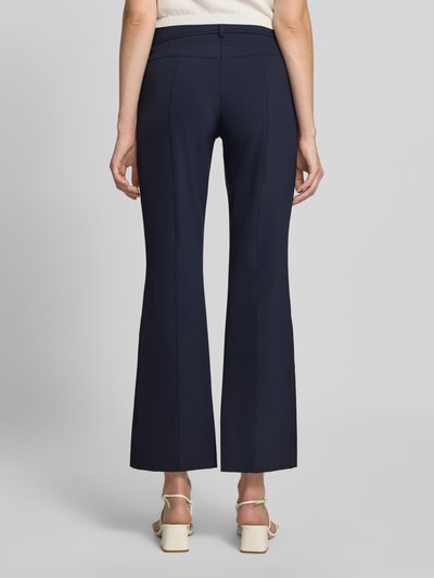 Vrouwenmodel draagt donkerblauwe slim fit broek met opgestikte zakken, Slim Fit Schmale Hose mit aufgesetzten Taschen model 'FARAH' van CAMBIO, dames broek, volledige lichaamsweergave achterkant.