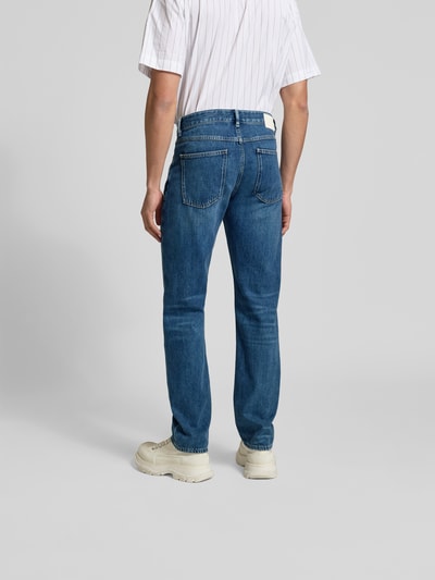 Männermodel trägt Straight Fit Jeans mit Logo-Patch von Closed in Blau, 5-Pocket-Design, reine Baumwolle, Ganzkörperansicht Rückansicht.