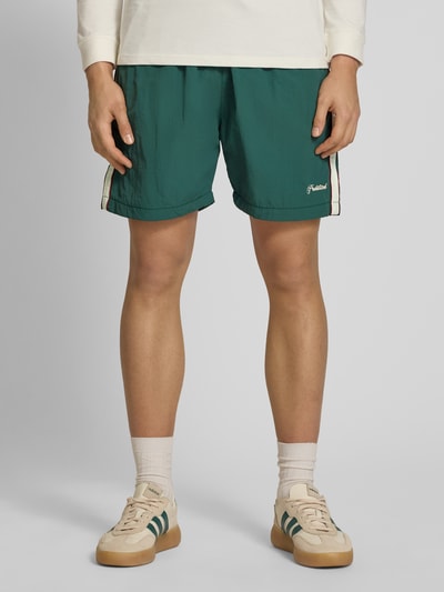 Männermodel trägt grüne Shorts mit Label-Stitching Modell 'Slipstream' von PROHIBITED, Regular Fit, elastischer Bund, Ganzkörperansicht von vorne.