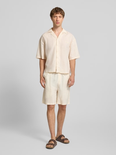 Männermodel trägt Leinenshorts mit elastischem Bund und Tunnelzug von ANOTHER COTTON LAB aus reinem Leinen Regular-Fit, cremefarben, Ganzkörperansicht von vorne.