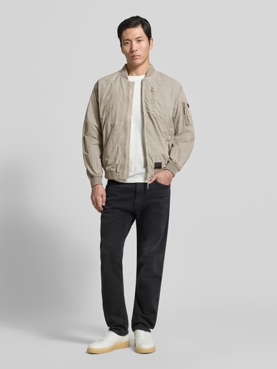 Männermodel trägt Blouson mit Label-Patches Modell 'IBE' von khujo in Beige, Gerader-Schnitt, Reißverschluss, Ganzkörperansicht von vorne.