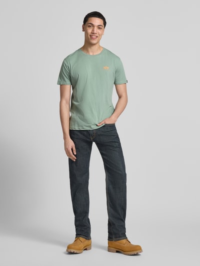Männermodel trägt Herren T-Shirt mit Label-Details Modell 'BASIC' von Alpha Industries in Mint, Reine Baumwolle, Gerader-Schnitt, Rundhalsausschnitt, Rückenlänge bei Größe M 67 cm, Ganzkörperansicht von vorne.