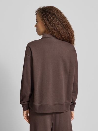 Vrouwenmodel draagt Sweatshirt mit Polokragen und Knopfleiste van Gina Tricot in bruin, regular fit, schouderdetails, rugaanzicht.