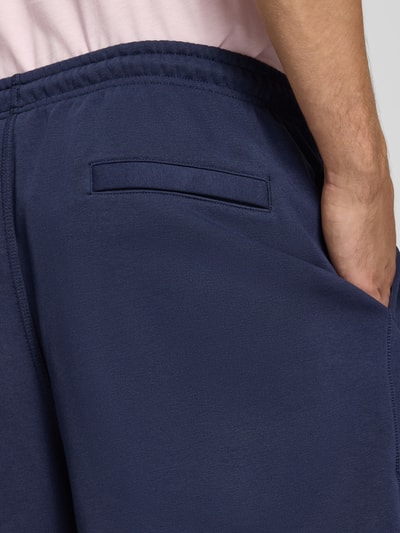 Männermodel trägt Regular Fit Sweatshorts aus Baumwoll-Mix von Nike in Dunkelblau mit glatter Struktur, Nahaufnahme Hüfte, Herren Sweatshorts von Nike.