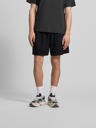 Männermodel trägt Shorts mit Logo-Stitching von Kenzo in Schwarz, Straight Fit, elastischer Bund, Eingrifftaschen, Ganzkörperansicht von vorne.