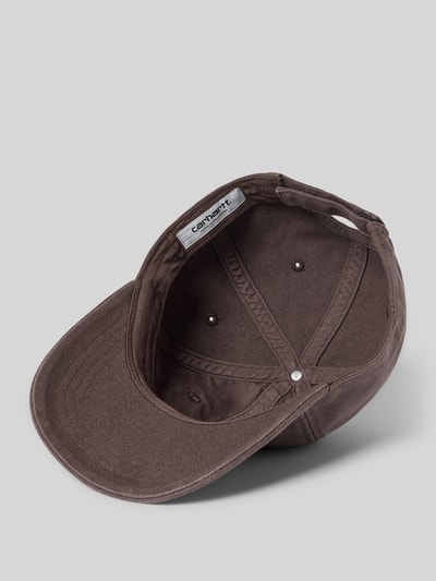 Produktfoto, Cap mit Label-Detail von Carhartt Work In Progress aus reiner Baumwolle in Braun mit verstärktem Schirm und verstellbarem Riegel mit Klettverschluss.