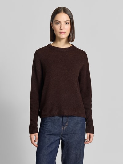 Modelka nosi sweter z dzianiny Relaxed Fit Strickpullover aus Woll-Mix mit Alpaka-Anteil von FREE/QUENT, mieszanka wełny z domieszką alpaki, okrągły dekolt, prążkowane wykończenia, długość tyłu w rozmiarze S: 58 cm, długość rękawów w rozmiarze S: 56 cm, ciemnobrązowy kolor, prosta forma, tekstura miękka, Ganzkörperansicht von vorne.
