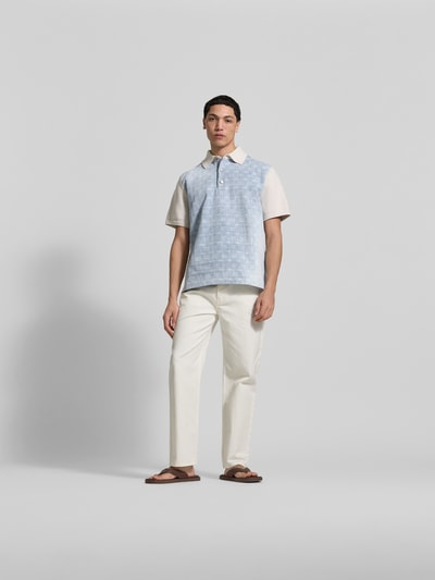 Männermodel trägt Regular Fit Poloshirt aus Baumwolle von Dsquared2 in Hellblau mit Denim-Besatz und Polokragen, Ganzkörperansicht von vorne.