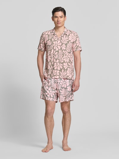 Männermodel trägt Freizeithemd im Allover-Look Modell 'Melo' von BOARDIES, rosa-beige, florales Muster, Regular Fit, Ganzkörperansicht von vorne. Produkt aus reinen LENZING™ ECOVERO™ Fasern mit Reverskragen, Brusttasche, kurzer Ärmel.