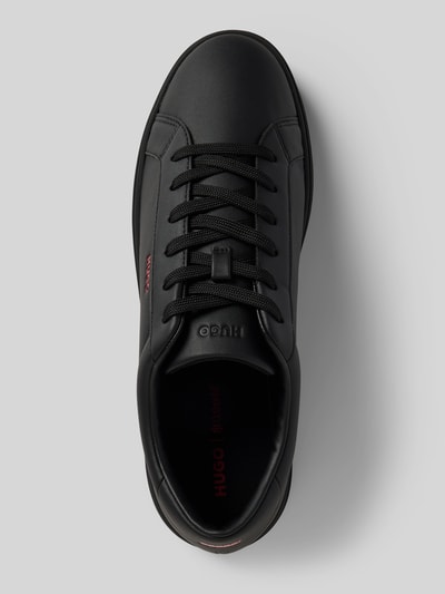 Produktfoto, Low Top Sneaker mit Label-Prägung Modell 'NESTON_TENN_PU' von HUGO in schwarzer Lederoptik, flacher Absatz, strukturierte Sohle, unifarbenes Design, Kunstleder, runde Schuhspitze, sichtbare Schnürung.