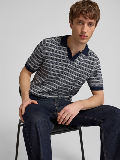 Männermodel trägt Regular Fit Poloshirt aus reiner Bio-Baumwolle Modell 'TILO' von Only & Sons mit Optik:Allover-Muster, Strick-Textur, Nahaufnahme Oberkörper.
