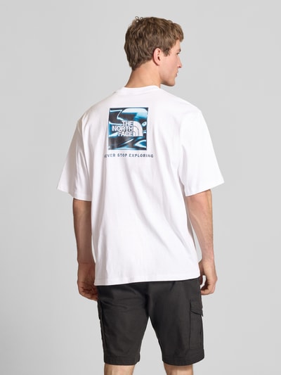 Männermodel trägt Oversized T-Shirt mit Logo und Rundhalsausschnitt von The North Face in Weiß, reine Baumwolle, Rückenlänge 73 cm, Ganzkörperansicht Rückansicht.