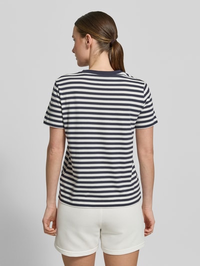 Frauenmodel trägt T-Shirt mit Rundhalsausschnitt und Label-Stitching von Gant aus Reine Baumwolle, Regular-Fit, Rückenlänge 56 cm, Ganzkörperansicht Rückansicht.