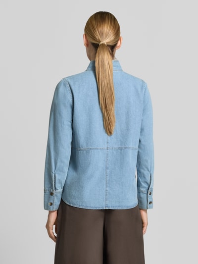 Frauenmodel trägt Regular Fit Hemdbluse aus reiner Baumwolle in Denim-Optik von Emily Van den Bergh, stójka, długi rękaw, tkanina stylizowana na denim, długość tyłu w rozmiarze 36: 61 cm, długość rękawów w rozmiarze 36: 58 cm, krój regular fit, całkowity widok od tyłu.