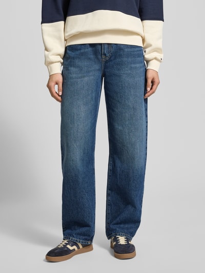 Männermodel draagt Tapered Fit Jeans uit pure katoen van Tommy Hilfiger, denim blauw met 5-pocket-design, voorkant, detailopname.