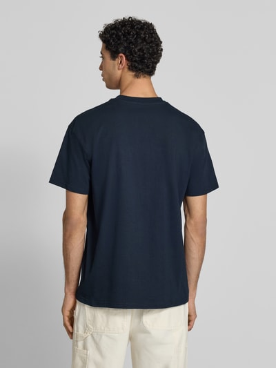 Männermodel trägt T-Shirt mit Label-Stitching und Rundhalsausschnitt von Carhartt Work In Progress, Reine Baumwolle, Regular-Fit, Rückenlänge 73 cm, Farbe Dunkelblau, Ganzkörperansicht Rückansicht.